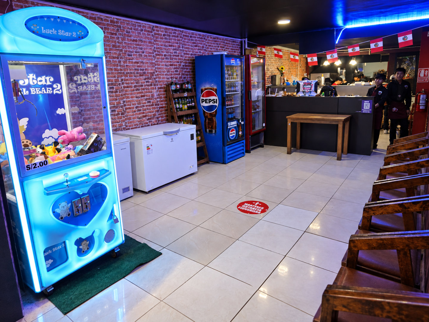 Zona de juegos y bebidas en el primer nivel de Manya Chicken Grill