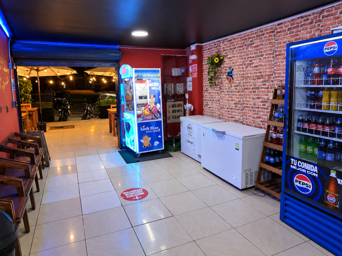 Entrada techada de Manya Chicken Grill con zona de juegos